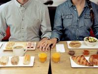 two people sitting at a table with food and drinks at ibis Paris Bastille Faubourg St Antoine in Paris