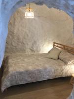 a bedroom with a bed in a stone wall at Casa Cueva “La Estrella” in Granada
