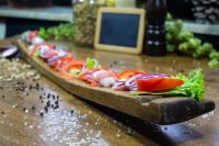 a pizza on a wooden cutting board on a table at Gasthaus & Hotel Drei Lilien in Werbach