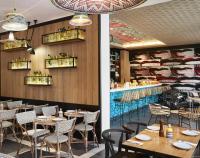 ニースにあるホリデイ イン ニースのテーブルと椅子とバーのあるレストラン