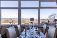 a dining room with a table and chairs and windows at Jagdschloss Hotel Niederwald in Rüdesheim am Rhein