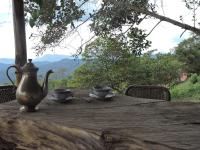 a wooden table with two cups and a tea pot on it at Eco-Cabañas Altozano Nimaima in Nimaima