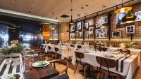 un restaurante con mesas, sillas y cuadros en la pared en Holiday Inn Perth City Centre by IHG, en Perth