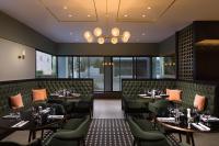 a restaurant with tables and chairs and a chandelier at Crowne Plaza Zürich by IHG in Zürich