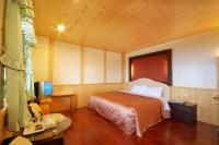 a bedroom with a bed and a desk and a television at Sea of Clouds Vacation Villa in Ren&#39;ai