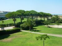 a park with green grass and trees and a sidewalk at AS13247 - P2 Cabine climatisé avec belle vue sur la Mer in Le Grau-du-Roi