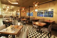 Un restaurante con mesas y sillas de madera en una sala. en Holiday Inn Hotel & Suites Hermosillo Aeropuerto by IHG, en Hermosillo