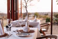 a group of tables with wine glasses and napkins at Cheetah Ridge Lodge in Nambiti Private Game Reserve
