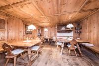 uma sala de jantar com paredes de madeira e mesas e cadeiras de madeira em Hotel Tann em Collalbo