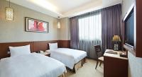 a hotel room with two beds and a television at Guanko Hotel in Chiayi City