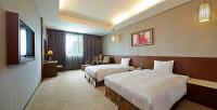 a hotel room with two beds and a couch at Guanko Hotel in Chiayi City