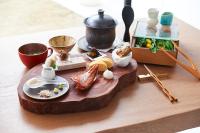 ein Tisch mit einem Holztablett mit Essen darauf in der Unterkunft Grand Bleu Gamin in Miyako-jima