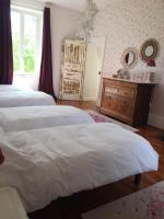 a bedroom with two beds and a dresser and a mirror at La Motte in Louroux-de-Bouble