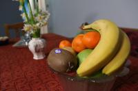 a bowl of fruit with bananas and oranges on a table at Nafpaktos Apartments in Nafpaktos
