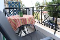 a table with a striped table cloth on a balcony at Nafpaktos Apartments in Nafpaktos