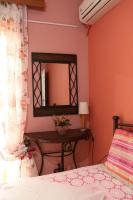 a bedroom with a bed and a mirror and a table at Nafpaktos Apartments in Nafpaktos