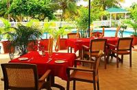 a restaurant with red tables and chairs and a pool at Anguilla Great House Beach Resort in Long Bay Village