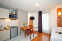 a room with a kitchen and a table and a bed at Séjours &amp; Affaires Nantes La Beaujoire in Nantes