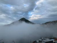 a mountain obscured by a layer of fog in a city at Liu House in Jiufen