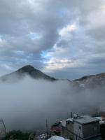 a view of a foggy city with a mountain in the background at Liu House in Jiufen