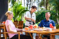 uma mulher conversando com um homem sentado à mesa em Eskala Hotels and Resorts em Ngwesaung