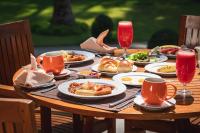 uma mesa de madeira com pratos de comida sobre ela em Eskala Hotels and Resorts em Ngwesaung