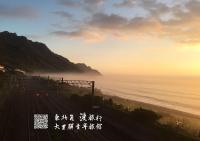 a group of people walking on the beach near the ocean at Dali Yi International Hostel in Toucheng