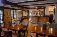 a restaurant with wooden tables and chairs and a bar at Stirrups Hotel in Bracknell