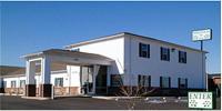 Un gran edificio blanco con un cartel delante. en Magnolia Inn and Suites Southaven, en Southaven