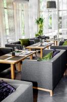 a restaurant with couches and tables and windows at Spa Hotel Ezeri in Sigulda