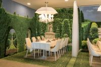 a dining room with a table and chairs and a wall of ivy at RAYA Garden - Park Hotel & Winery in Veliko Tŭrnovo