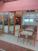 un ristorante con tavoli e sedie di fronte a un edificio di Liberta Malioboro South a Yogyakarta