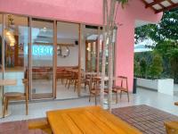 un ristorante con tavoli e sedie e un edificio rosa di Liberta Malioboro South a Yogyakarta
