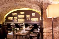 a restaurant with tables and chairs and a stone wall at Hotel Verneuil Saint Germain in Paris