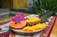 Ein Schneidebrett mit einer Ananas und Früchten auf einem Tisch in der Unterkunft Lagoona Beach Bungalows - Eco Stay in Pangandaran
