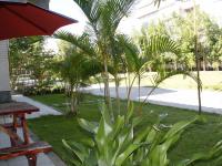 a park with palm trees and a bench and an umbrella at Feng Lin Homestay in Shuili