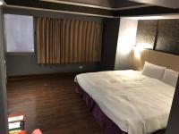 a bedroom with a large bed and a window at Long Siang Hotel in Kaohsiung