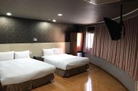 a hotel room with two beds and a television at Long Siang Hotel in Kaohsiung