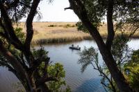 a boat on a river with some people in it at Namushasha River Campsite in Kongola