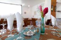 a table with a vase with a red flower in it at Karibea Squash Hôtel in Fort-de-France