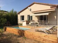 a deck with a pool and chairs and a house at Villa Caramel in Saint-Quentin-la-Poterie