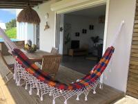 a hammock on a porch of a house at Gîte Maracudja vue sur mer in Capesterre-Belle-Eau