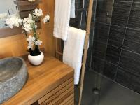 a bathroom with a vase of flowers on a wooden counter at Gîte Maracudja vue sur mer in Capesterre-Belle-Eau