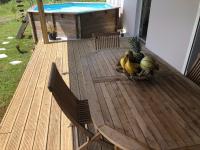 a bowl of fruit sitting on a wooden deck at Gîte Maracudja vue sur mer in Capesterre-Belle-Eau