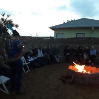 a man in uniform standing in front of a fire at DeKotzenhof in Wakkerstroom