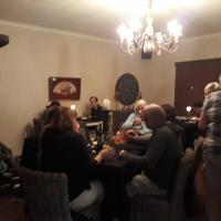 a group of people sitting around a table in a room at DeKotzenhof in Wakkerstroom