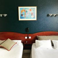 a bedroom with two beds and a painting on the wall at Grand Hotel De La Poste - Lyon Sud - Vienne in Vienne