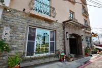 a brick building with a window and a balcony at Kenting Garden Homestay in Kenting