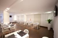 uma sala de jantar com mesas e cadeiras brancas em King Motel王者 em Taoyuan