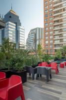 un grupo de mesas y sillas en una azotea con edificios en Hotel Nodo - El hotel que respira, en Santiago
